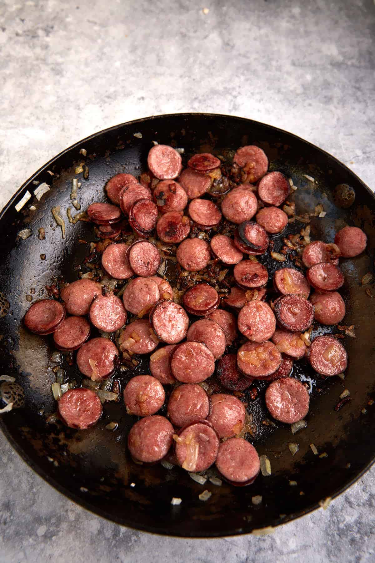 Cooked smoked sausage in a skillet.