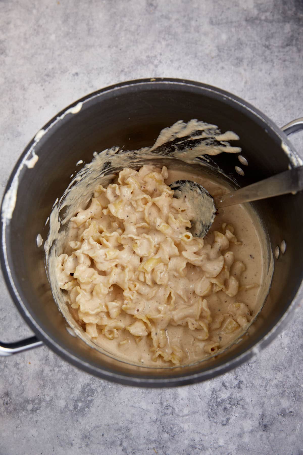 A pot of pasta with cheese sauce.