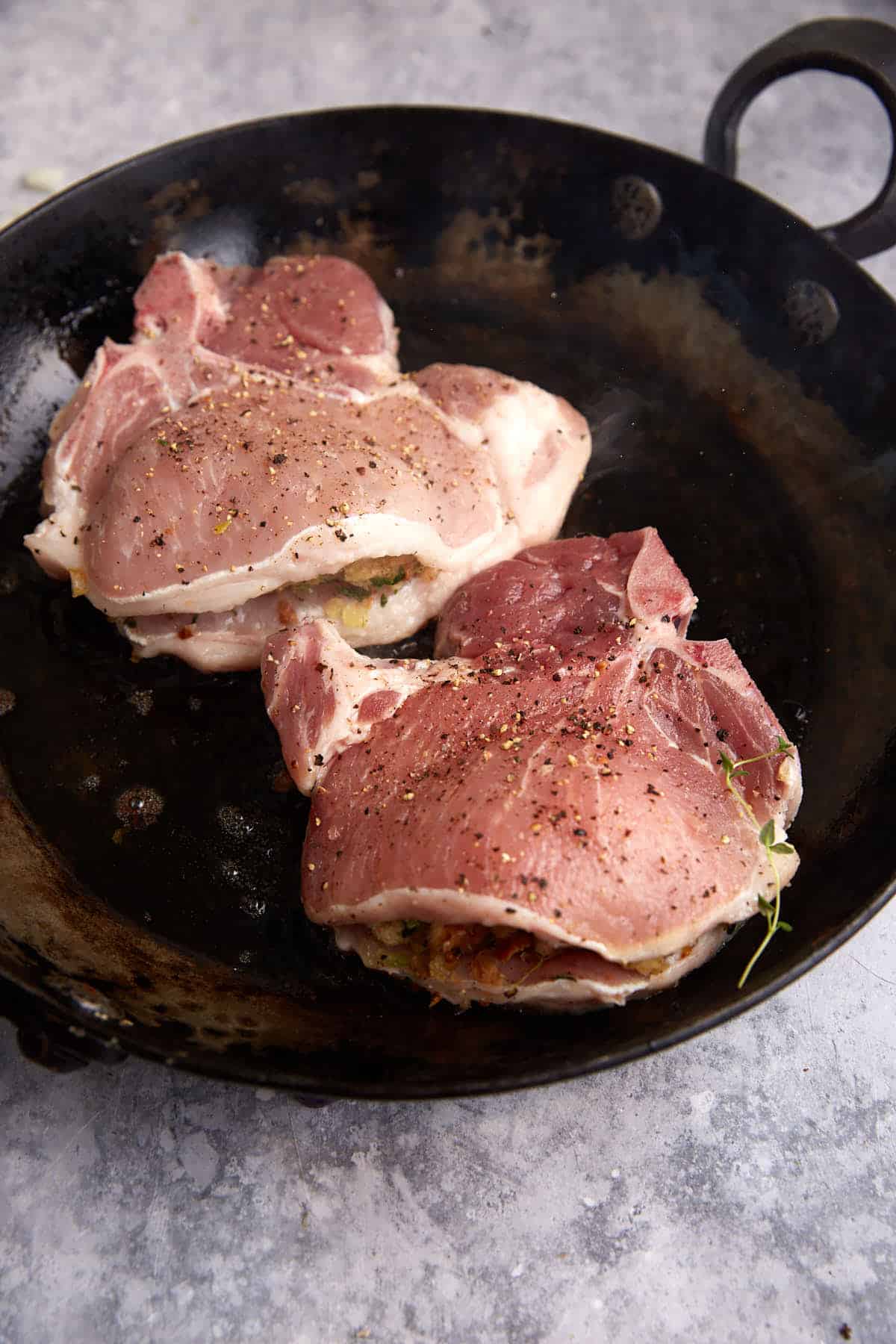Two pork chops in a skillet.