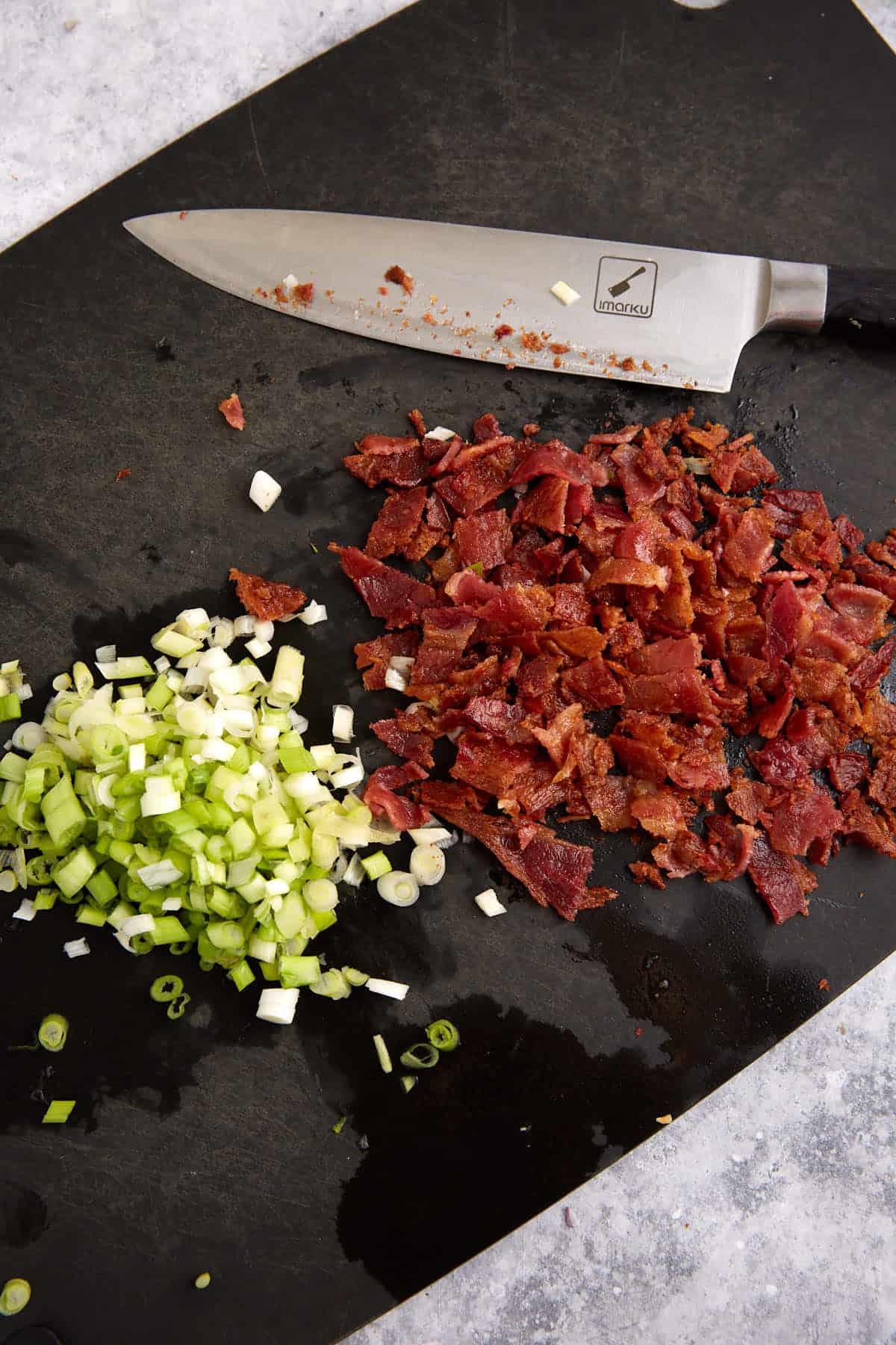 Cooked bacon chopped on a cutting board.