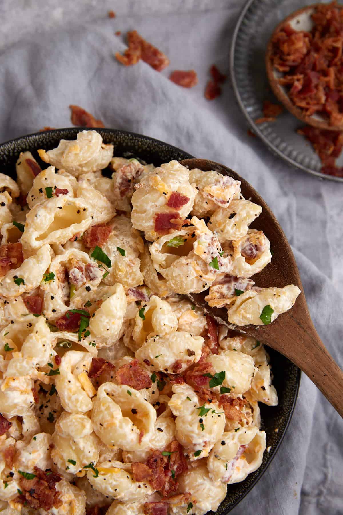 Ranch pasta salad in a bowl with a wooden spoon.