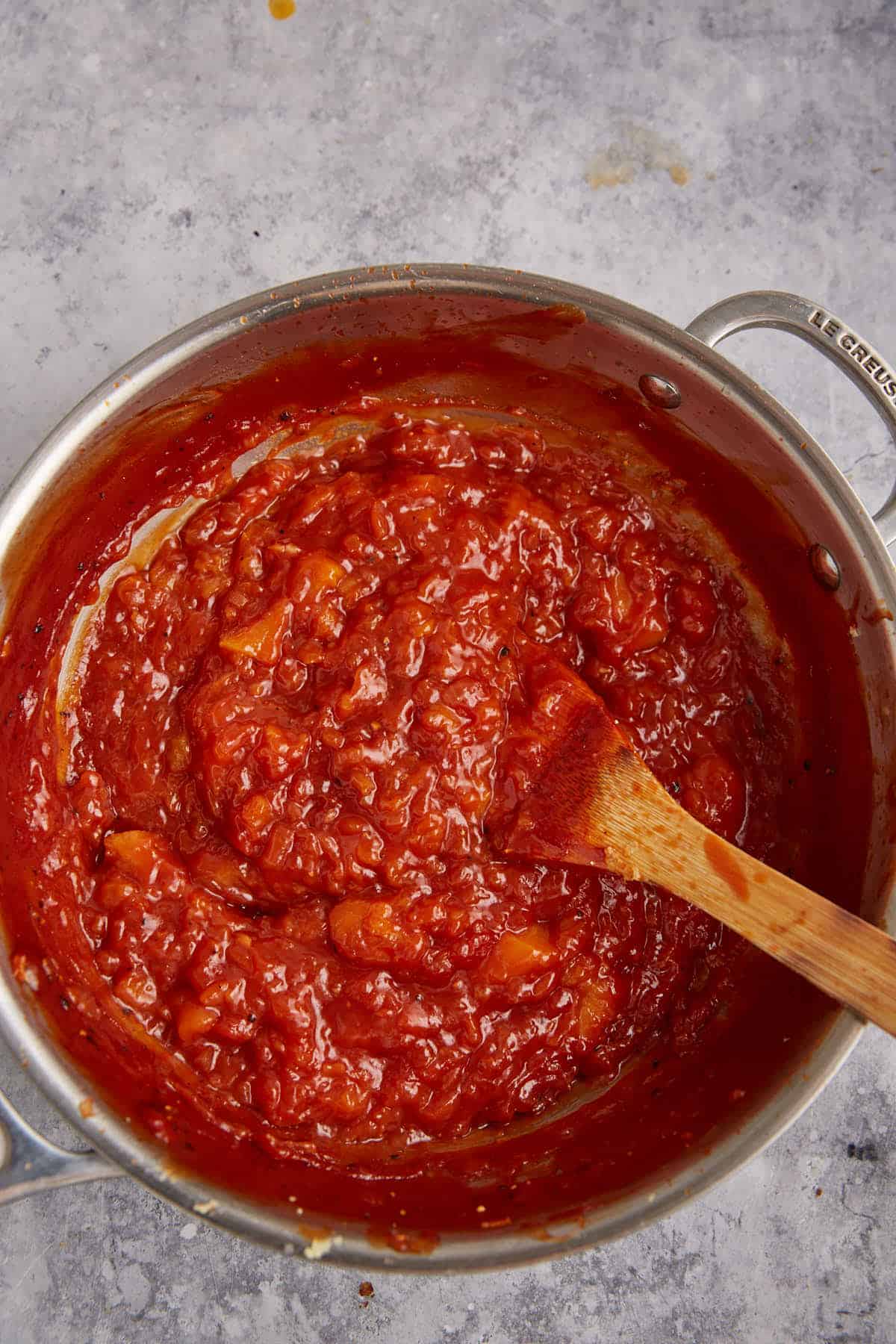 Finished bbq peach sauce in a saucepan.