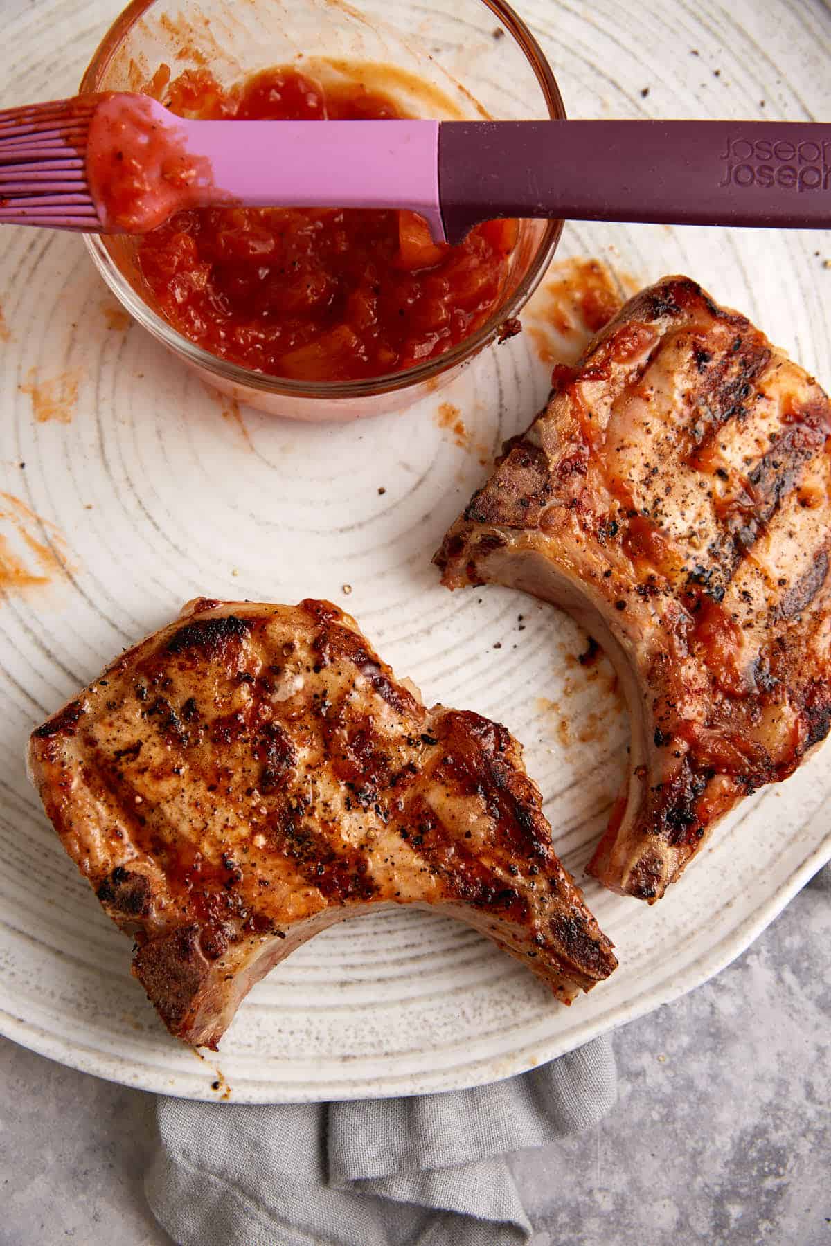 Two pork chops resting after being grilled.