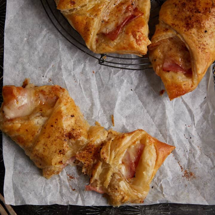 A ham and cheese pastry broken in half.