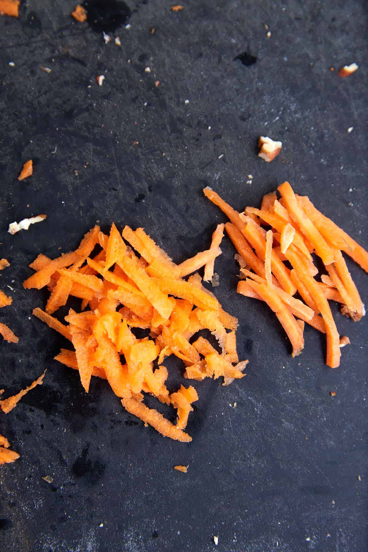 Carrots shredded with a box grater next to pre-shredded carrots.