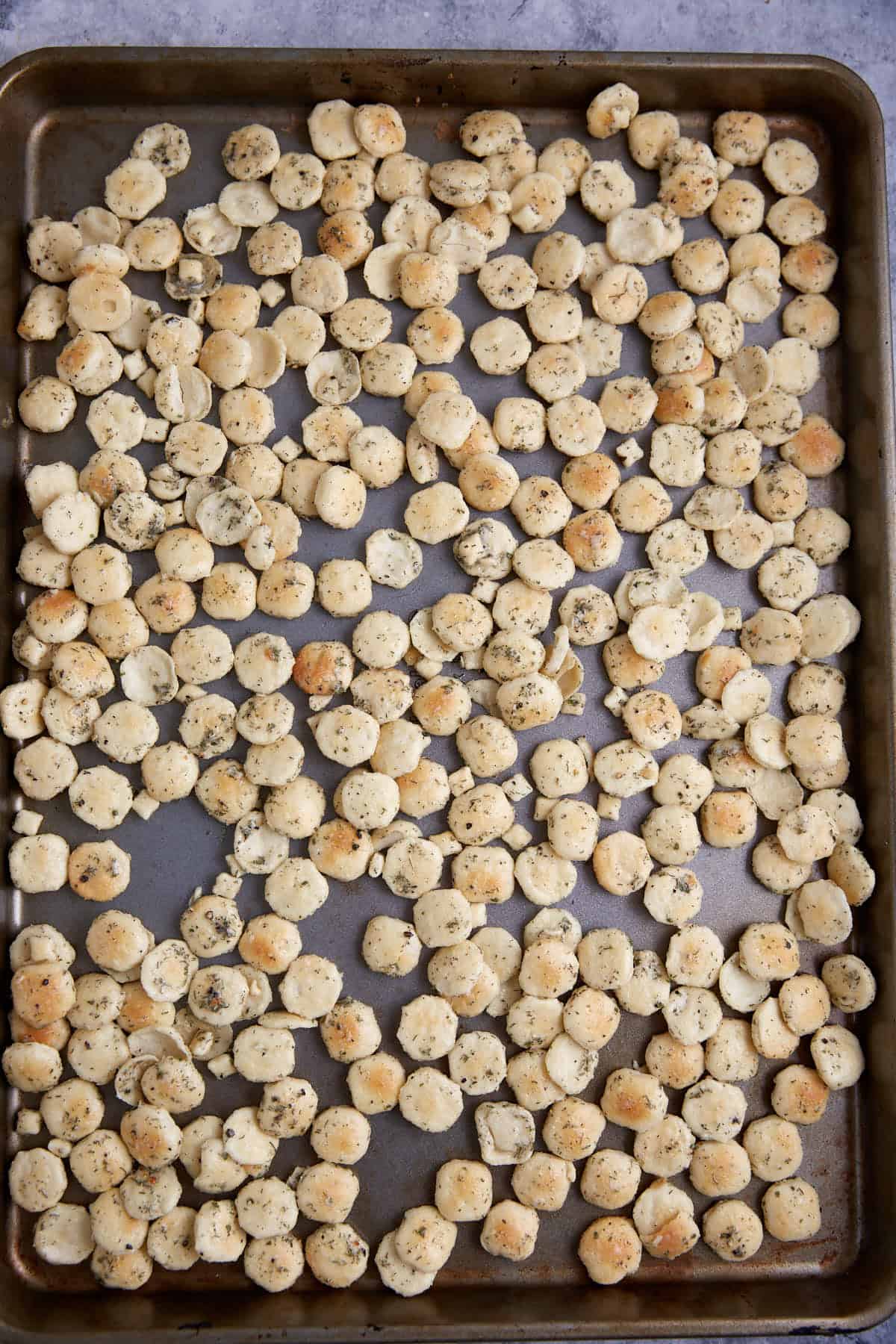 Seasoned crackers on a baking sheet.