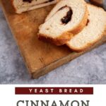 A loaf of cinnamon raisin bread sliced on a cutting board.