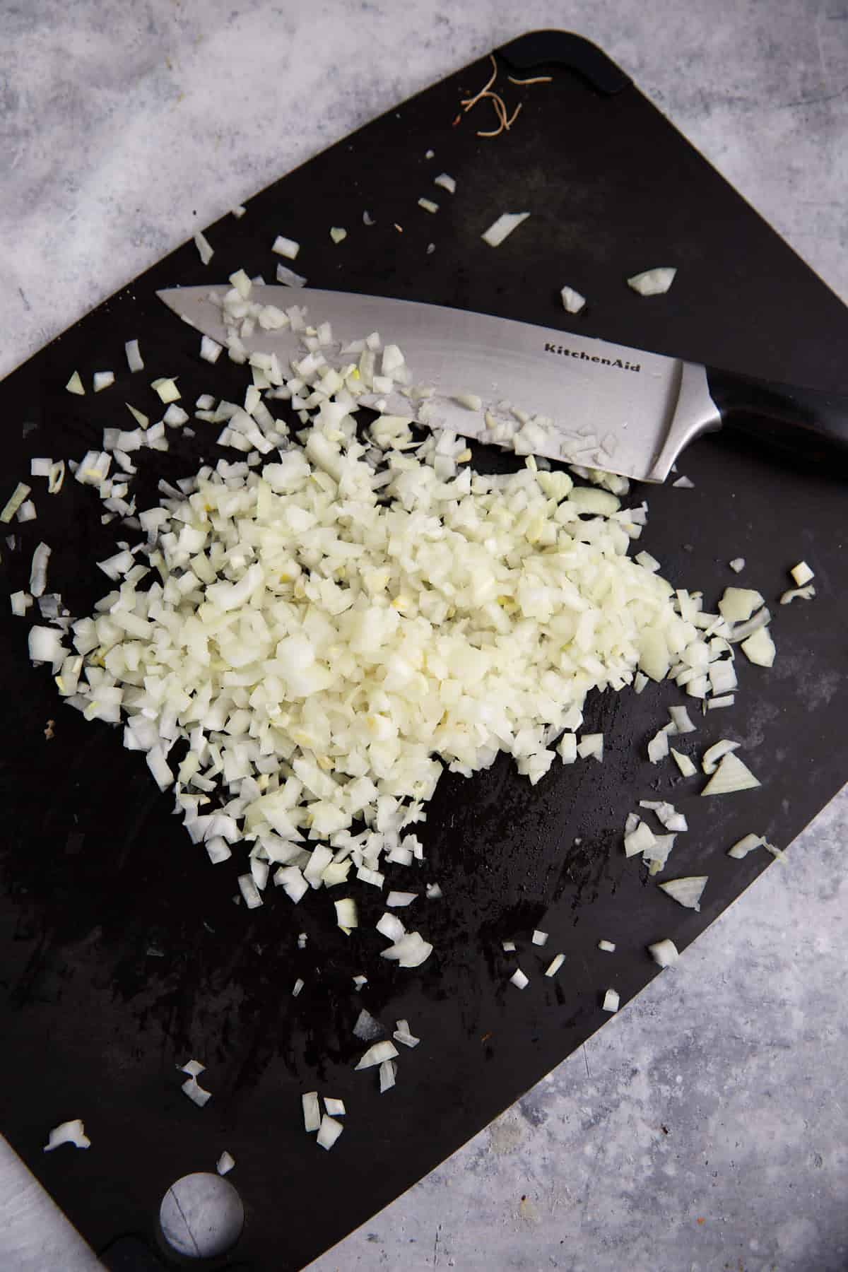 Chopped onions on a cutting board.