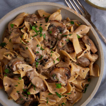 A serving bowl of creamy beef stroganoff with egg noodles.