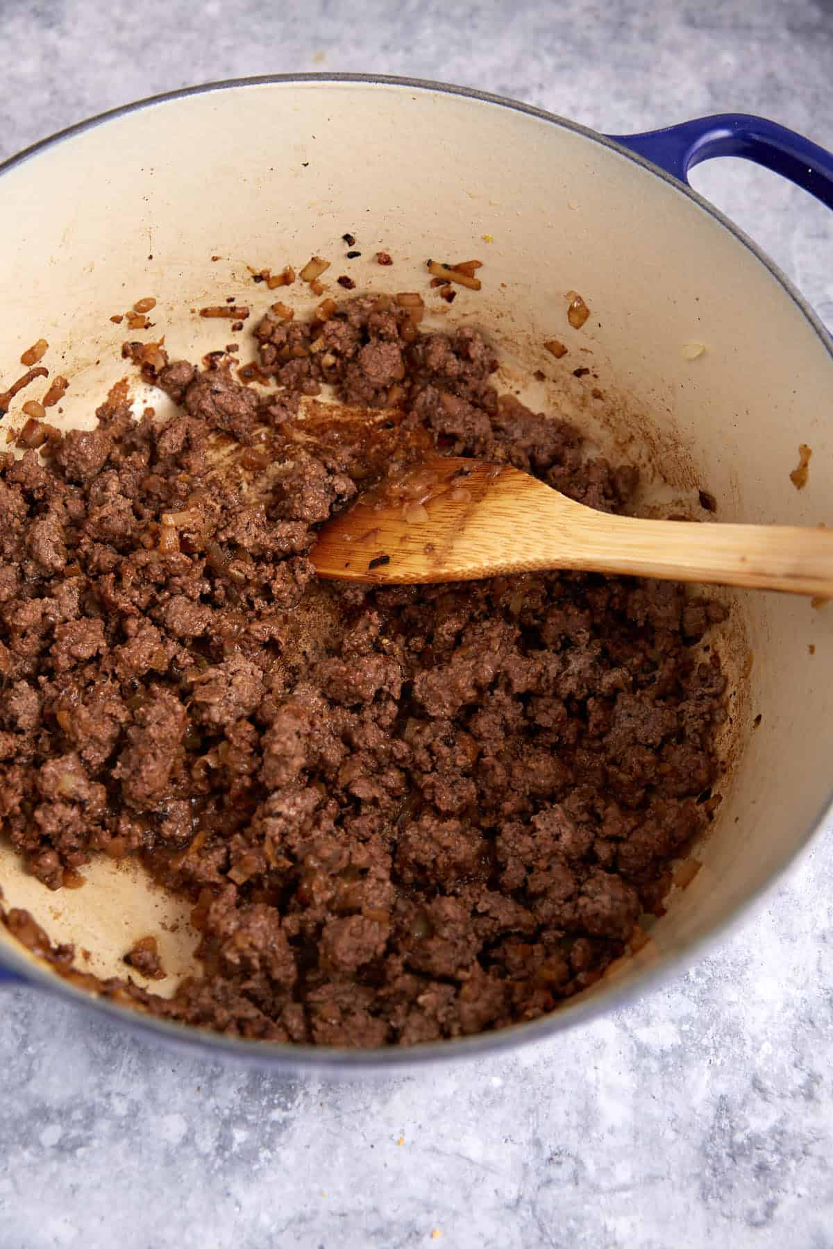 Cooked ground beef in a Dutch oven.