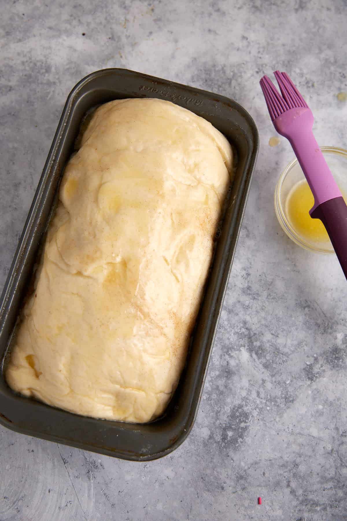 A loaf of cinnamon raisin swirl bread after it has risen in the pan.