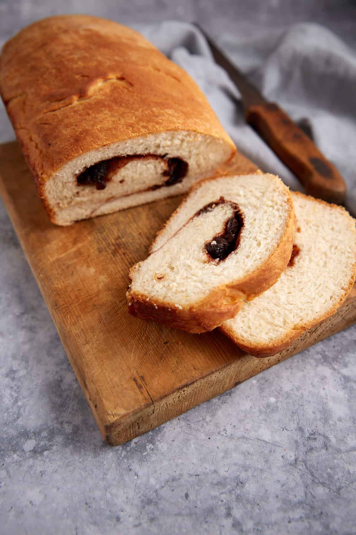 A loaf of cinnamon raisins bread with cut slices.