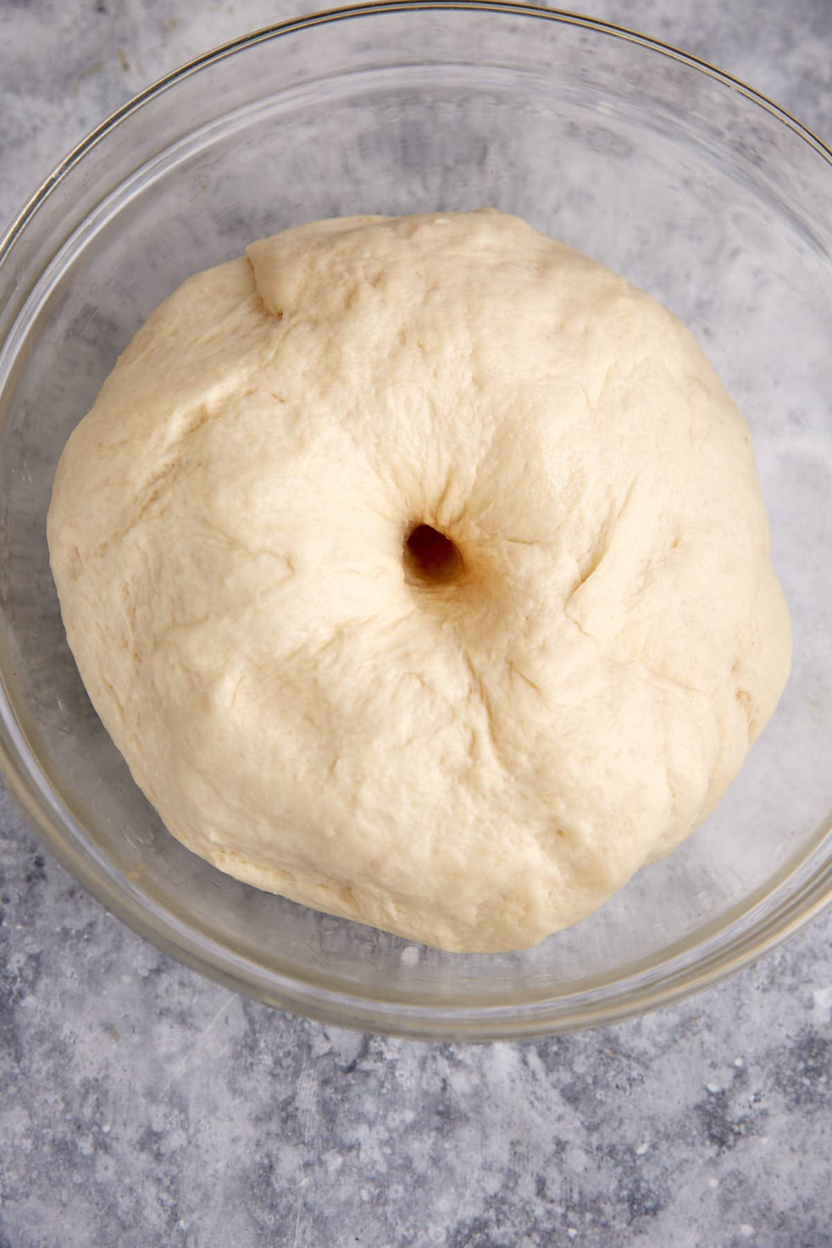 A bowl of dough which has risen with a finger hole in the center.