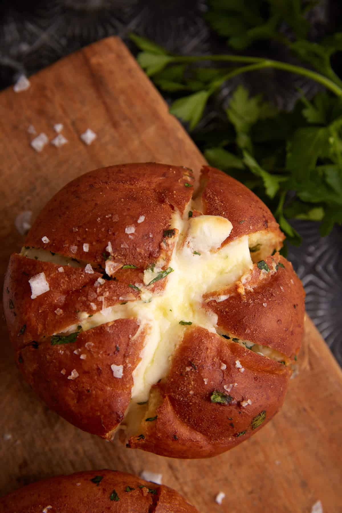 A single filled garlic roll on a wooden board.