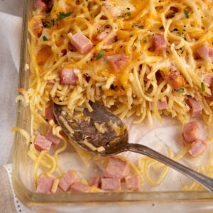 A ham and cheese casserole with a serving removed.