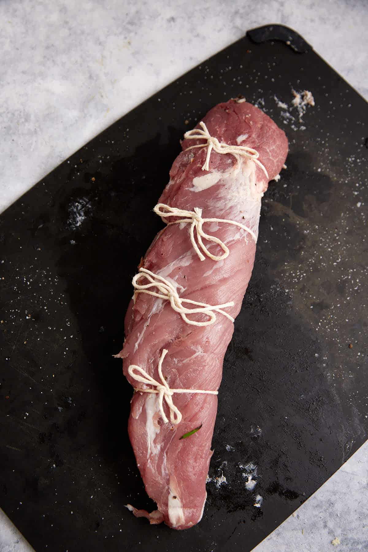 Twine wrapped around a stuffed pork tenderloin.