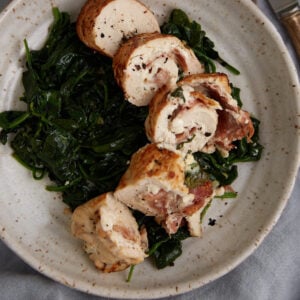 Cheese stuffed chicken breasts on a bed of spinach.