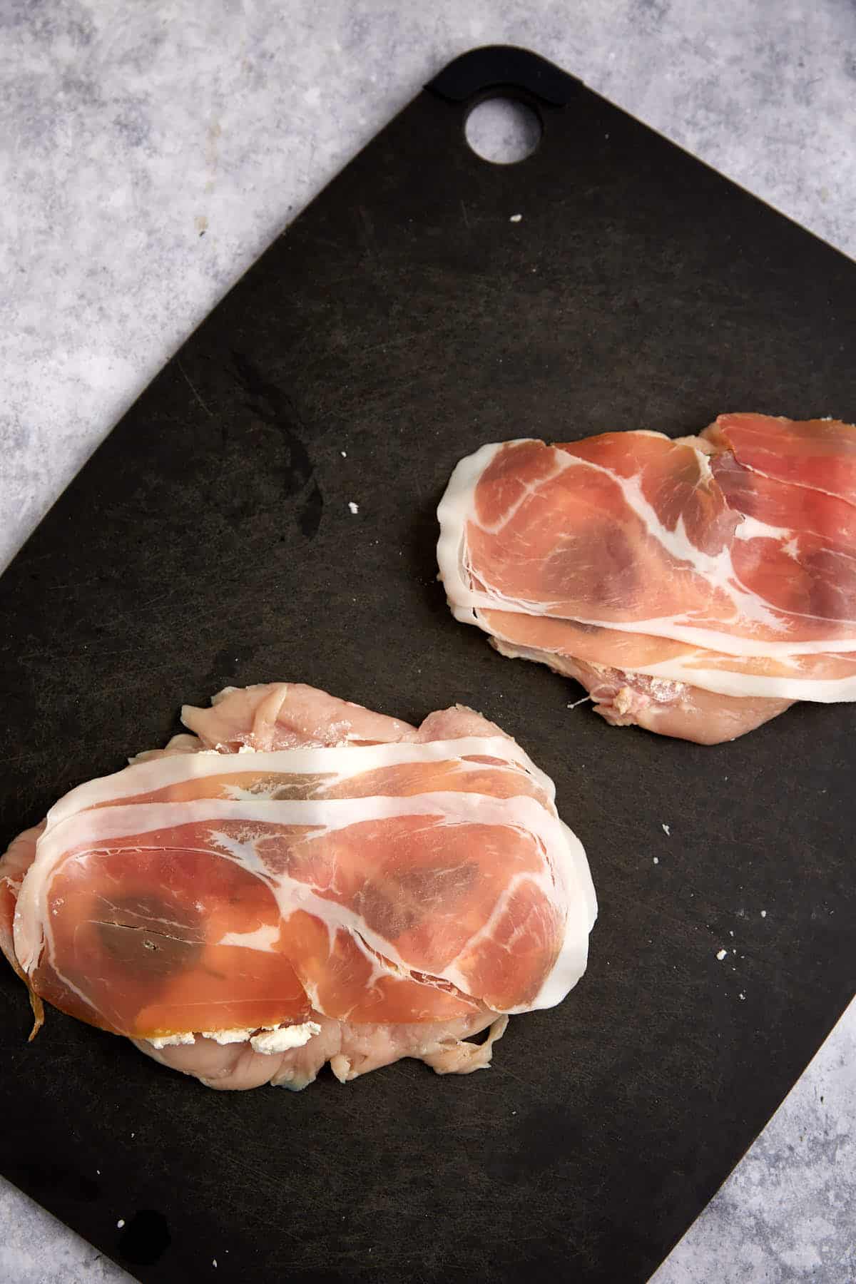 Prosciutto on top of chicken breasts.