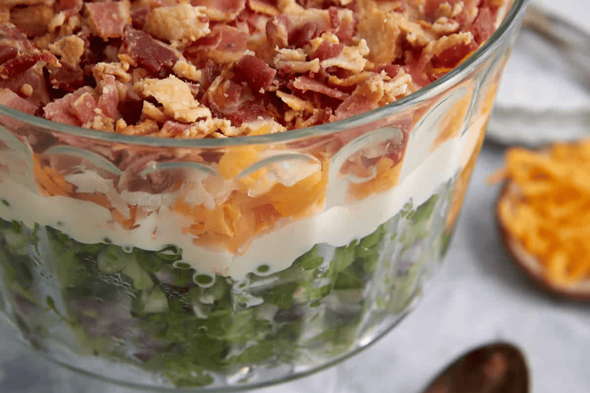 A glass dish with 7 layer salad.