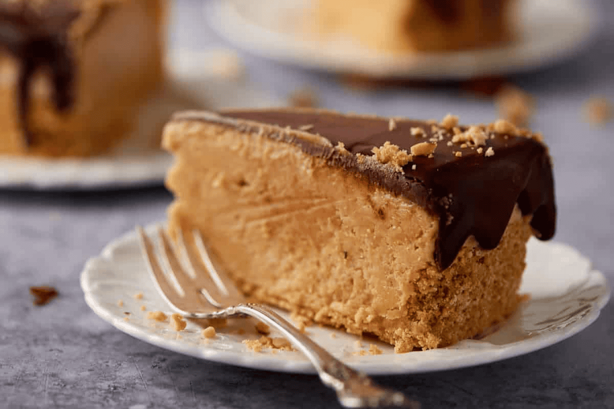 A slice of rich peanut butter pie on a plate with a fork.