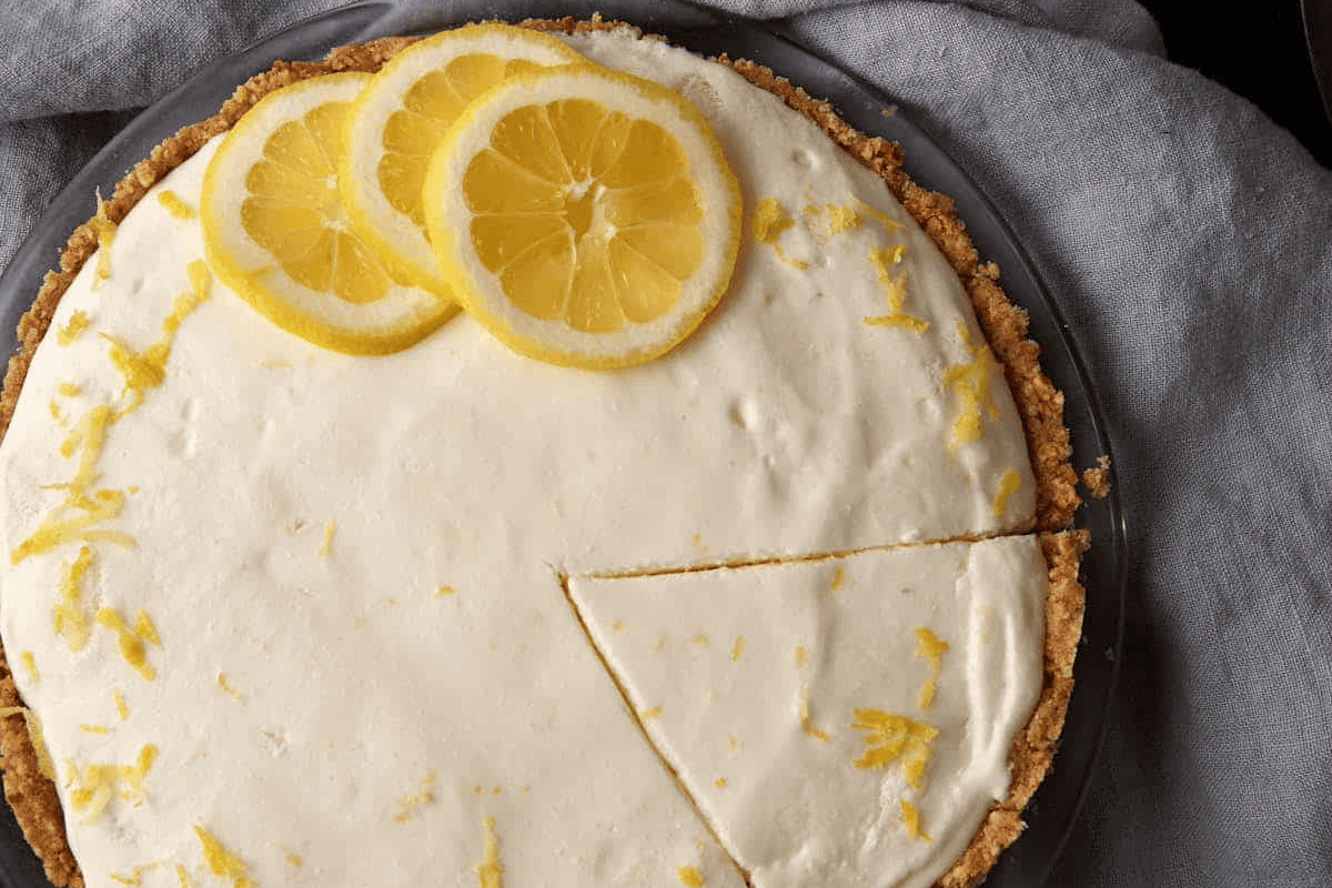 an entire lemon chiffon pie with a slice cut.