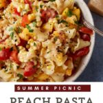 A serving bowl of pasta salad with peaches, corn and tomatoes.