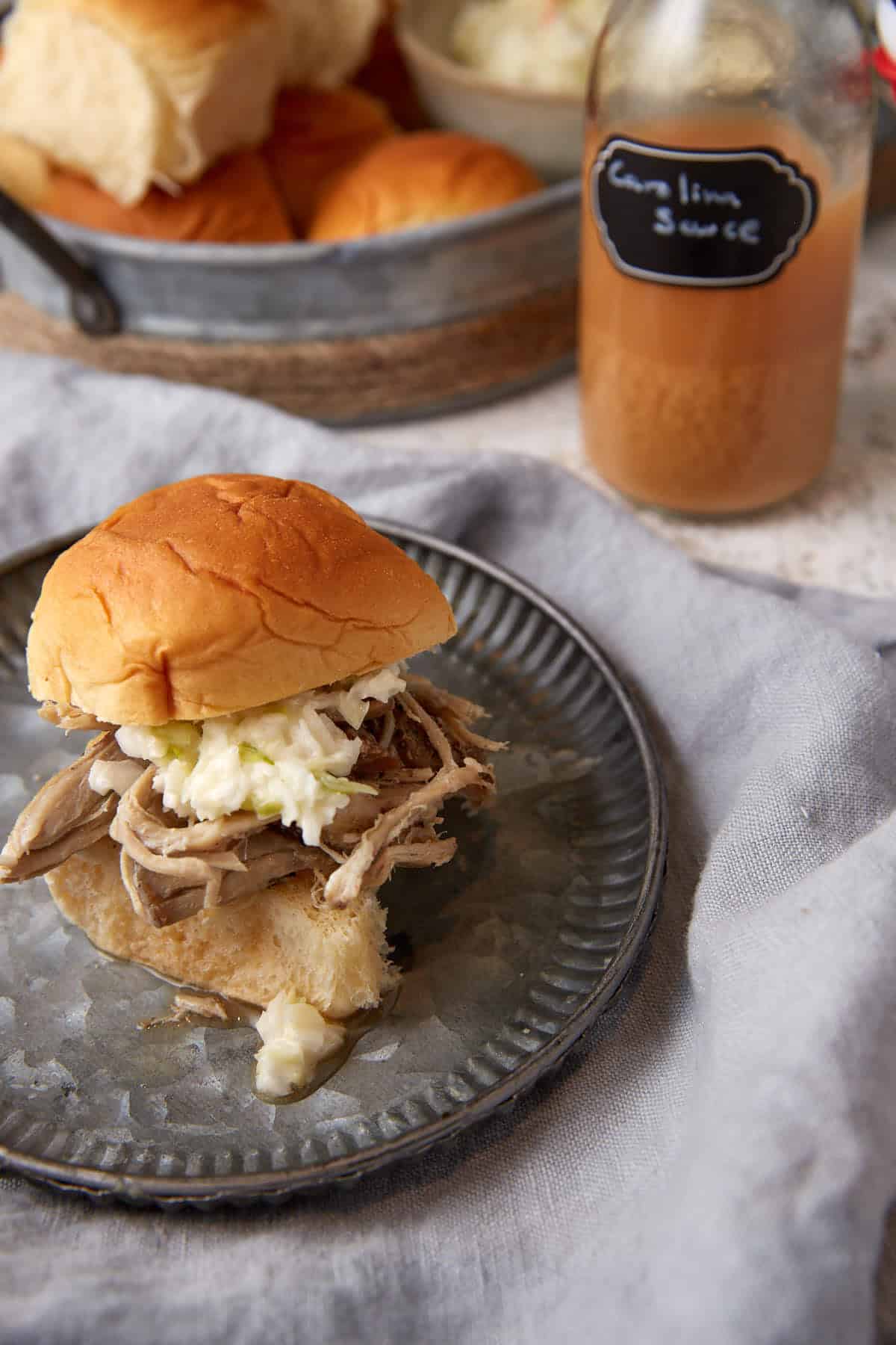 Pulled pork on a sandwich with carolina sauce.