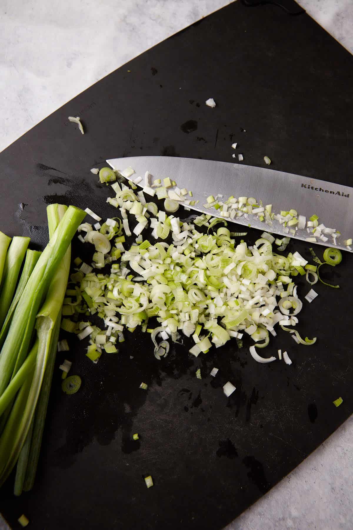 Chopped green onions on a cutting board.