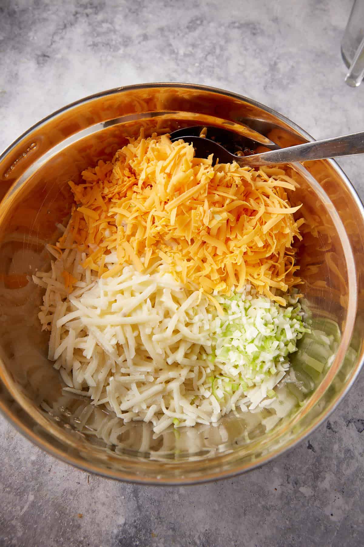 Cheese, hashbrown and chicken in a bowl.
