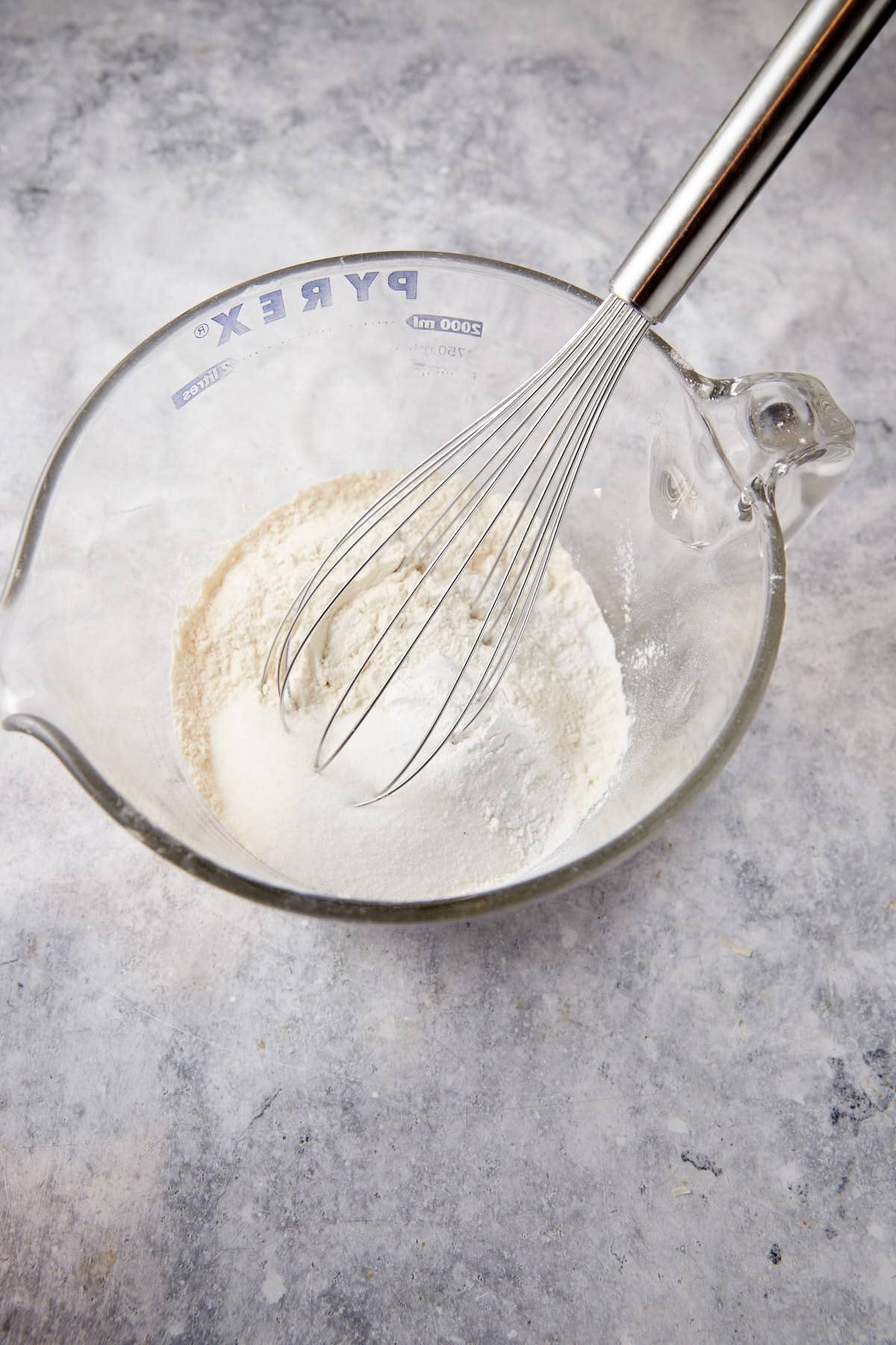 The dry ingredients in a bowl with a whisk.