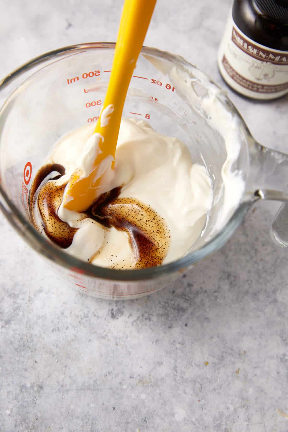 Creme fraiche and vanilla paste being mixed.