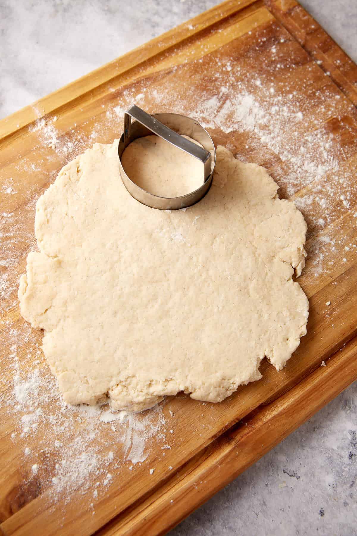 Biscuit dough cut into circles on a baking sheet.