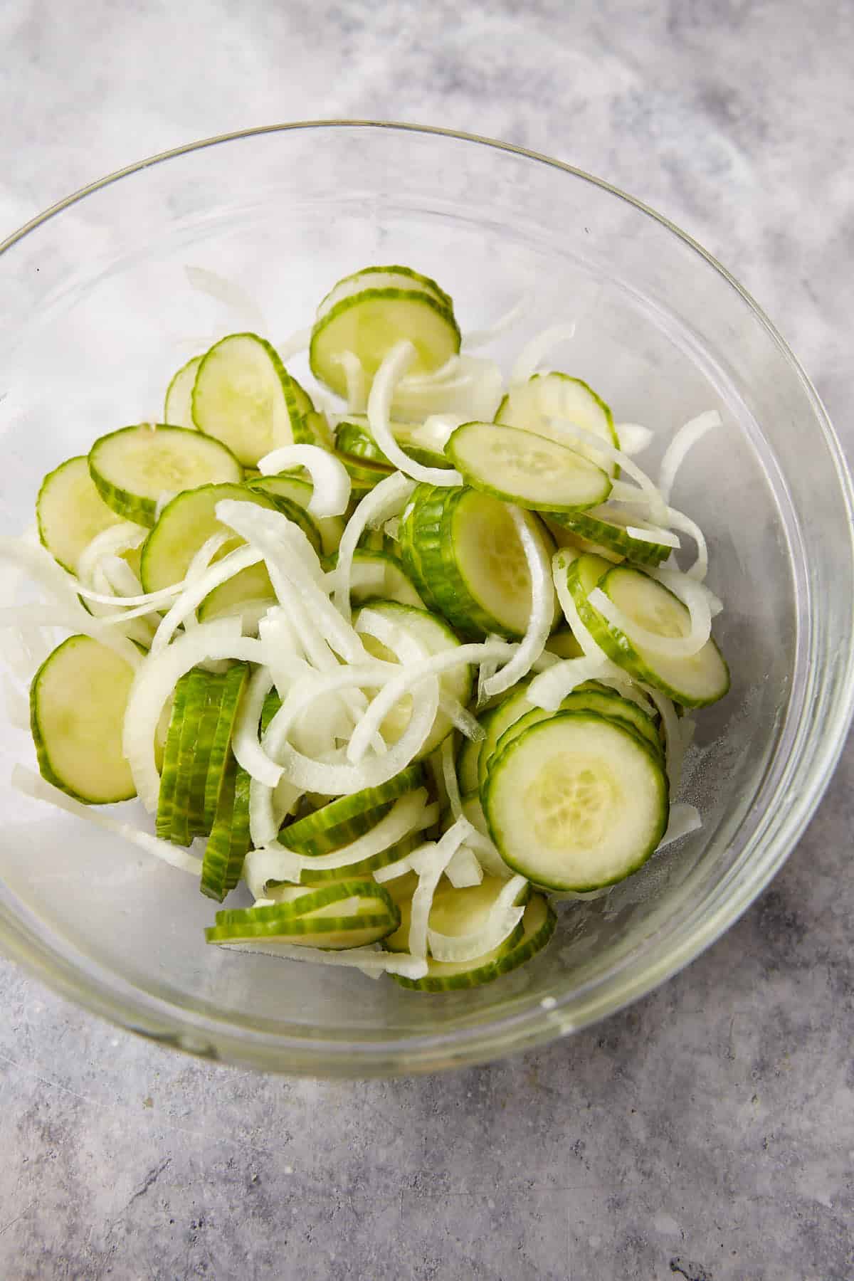 cucumbers and sliced onions in a bowl.