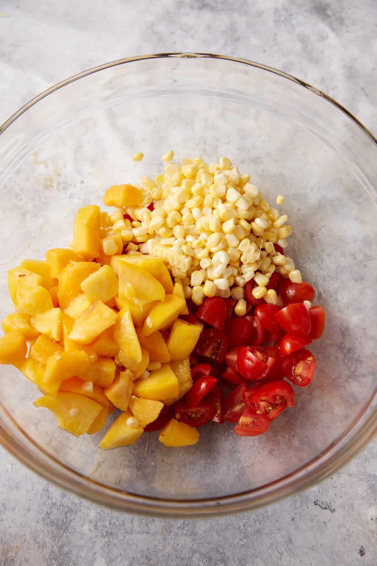 Chopped peaches, corn and tomatoes in a bowl.