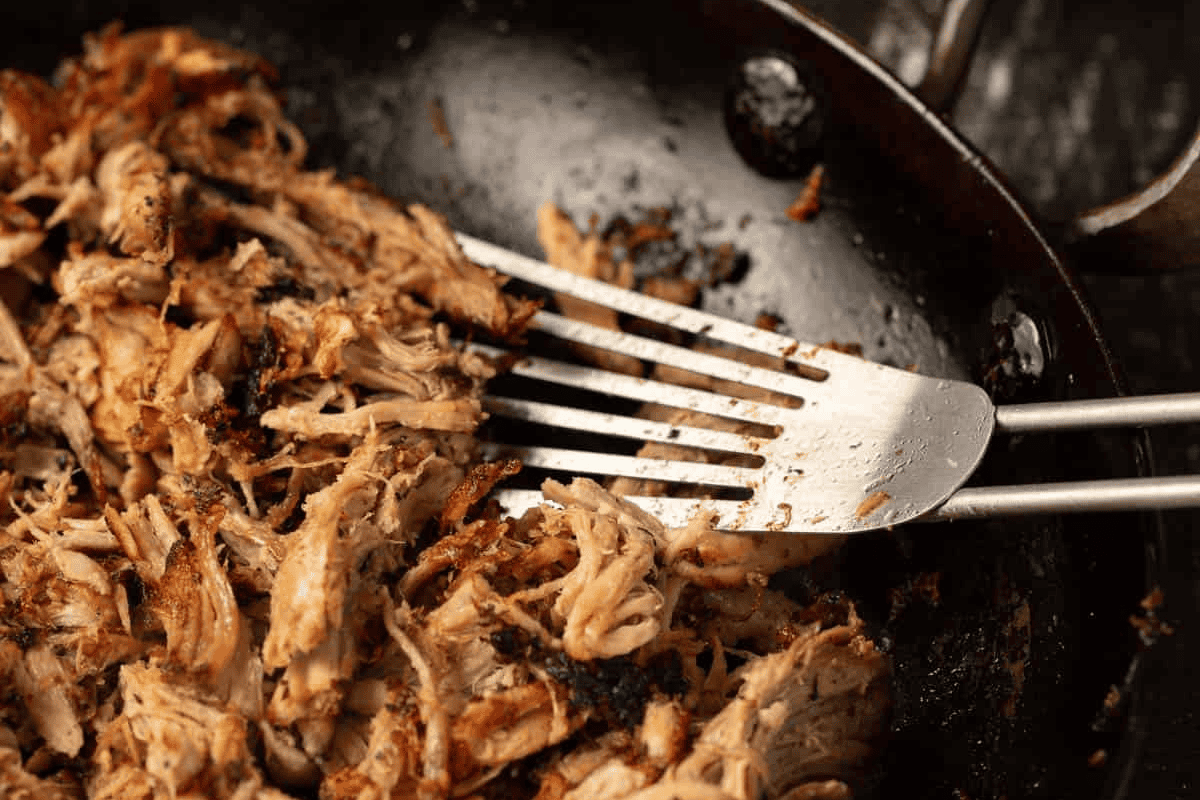 Pulled pork getting crispy in a skillet.