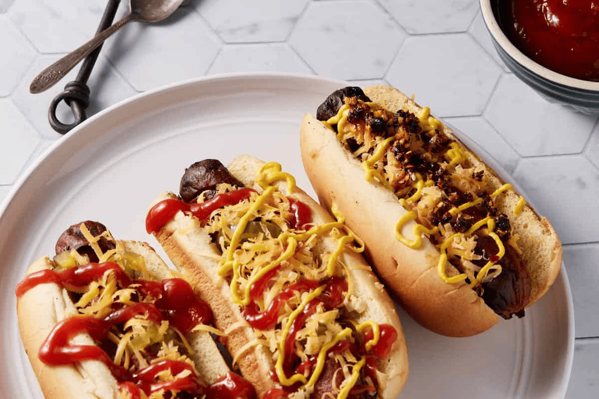 Spiraled hot dogs in buns covered in cheese.