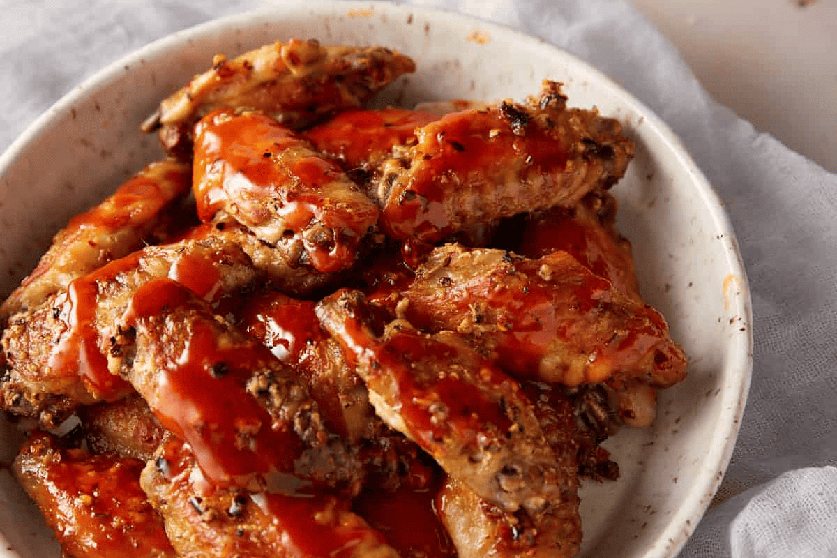 Baked buffalo wings in a serving bowl.