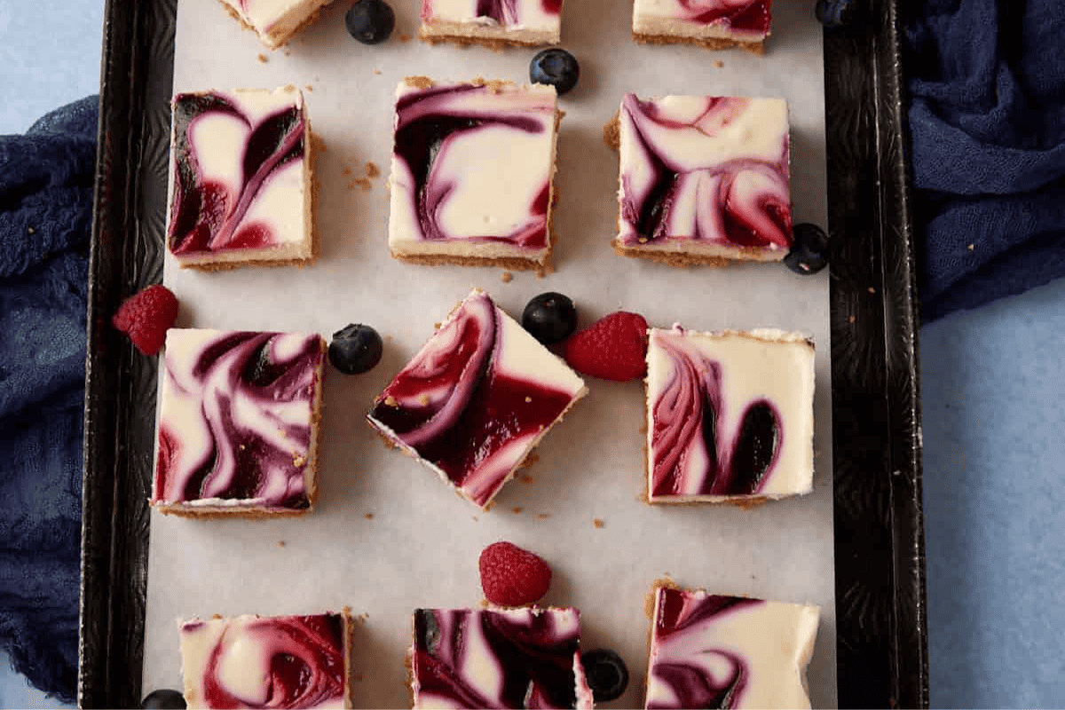 Blueberry cheesecake squares on a platter.