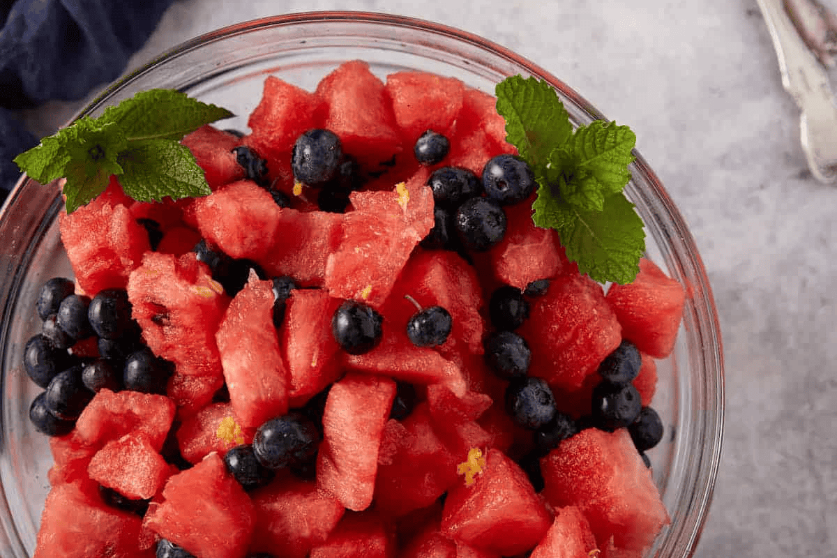 Watermelon and blueberry salad in a glass bowl.