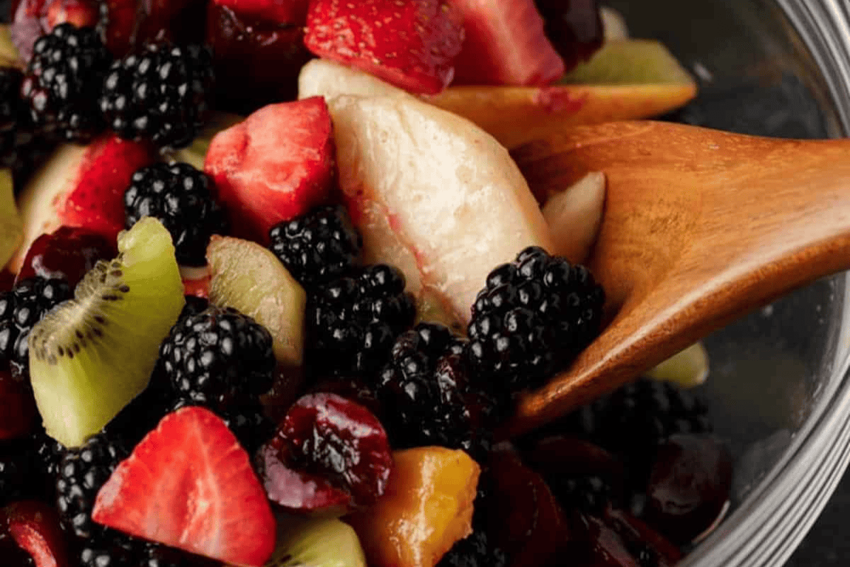 A wooden spoon with spicy fruit salad.