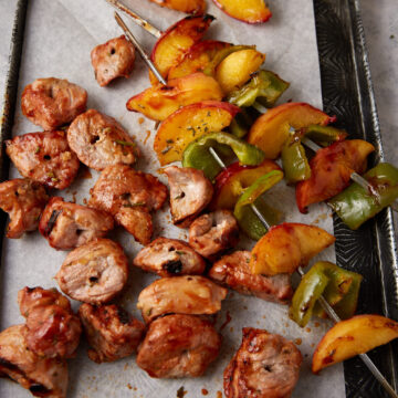 grilled pork and peaches on metal kabob skewers