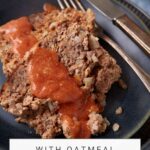 A close-up image of a plate with two slices of meatloaf topped with a red sauce.