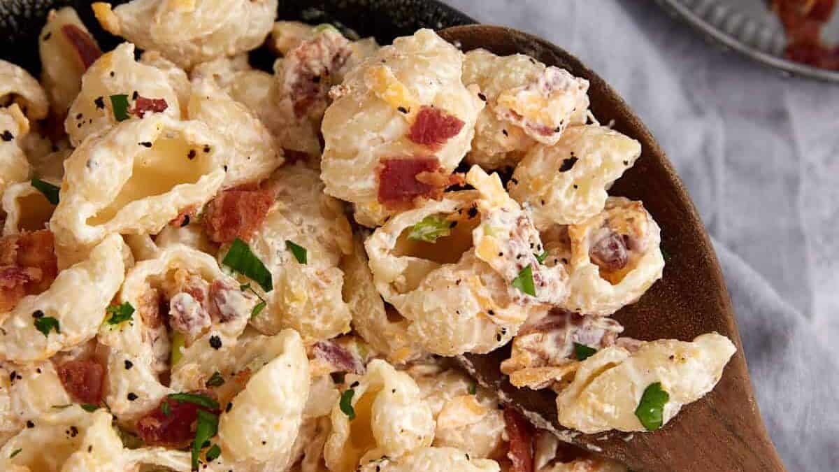 Ranch pasta salad in a bowl with a wooden spoon.