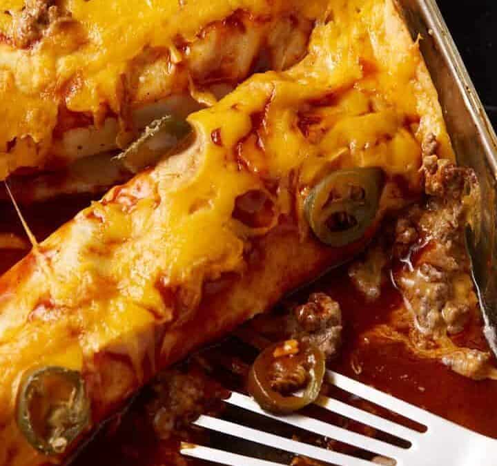 Beef and cheese enchiladas in a baking dish.