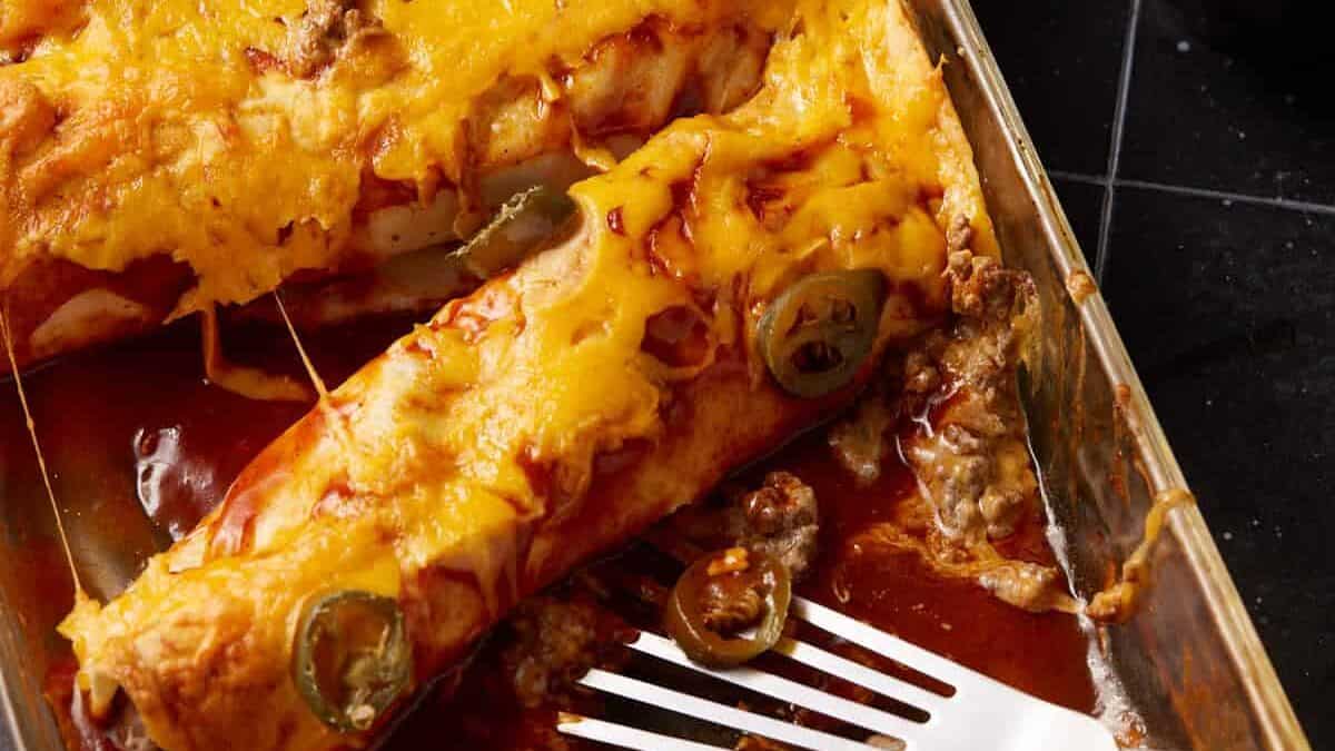 Beef and cheese enchiladas in a baking dish.