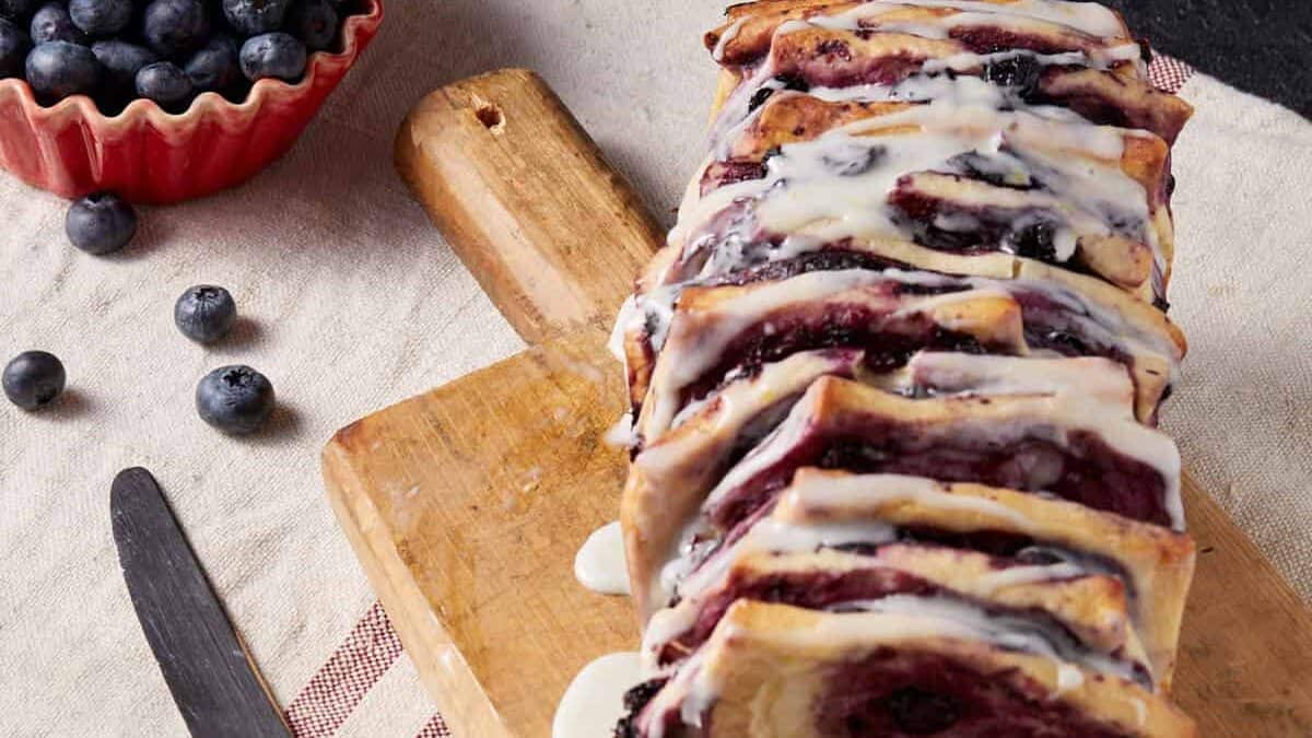 A loaf of blueberry bread on a cutting board.
