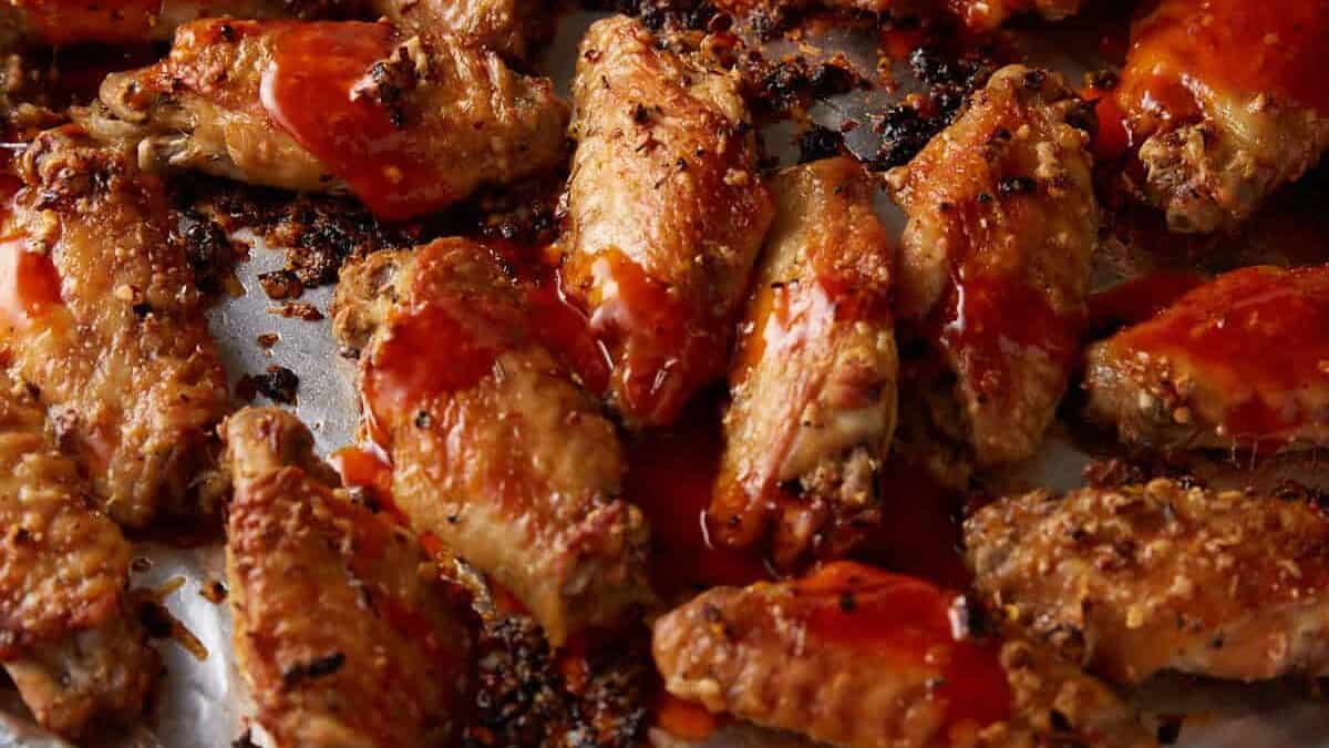 Buffalo wings on a foil covered baking sheet.