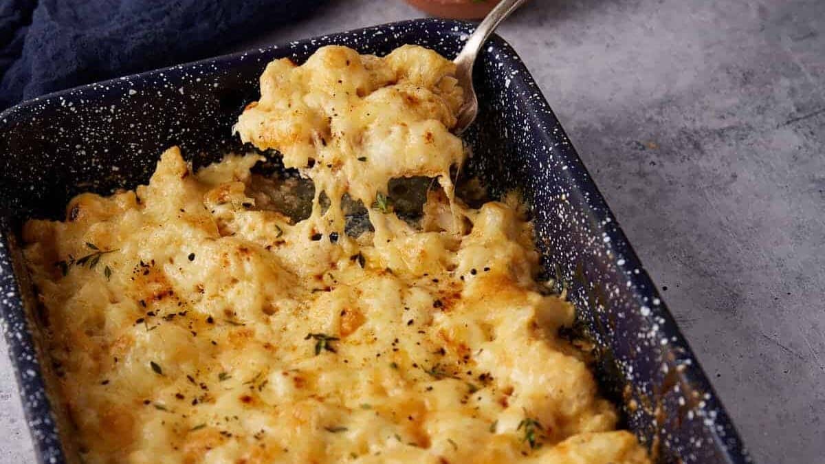 A spoon taking out a serving of cauliflower casserole.