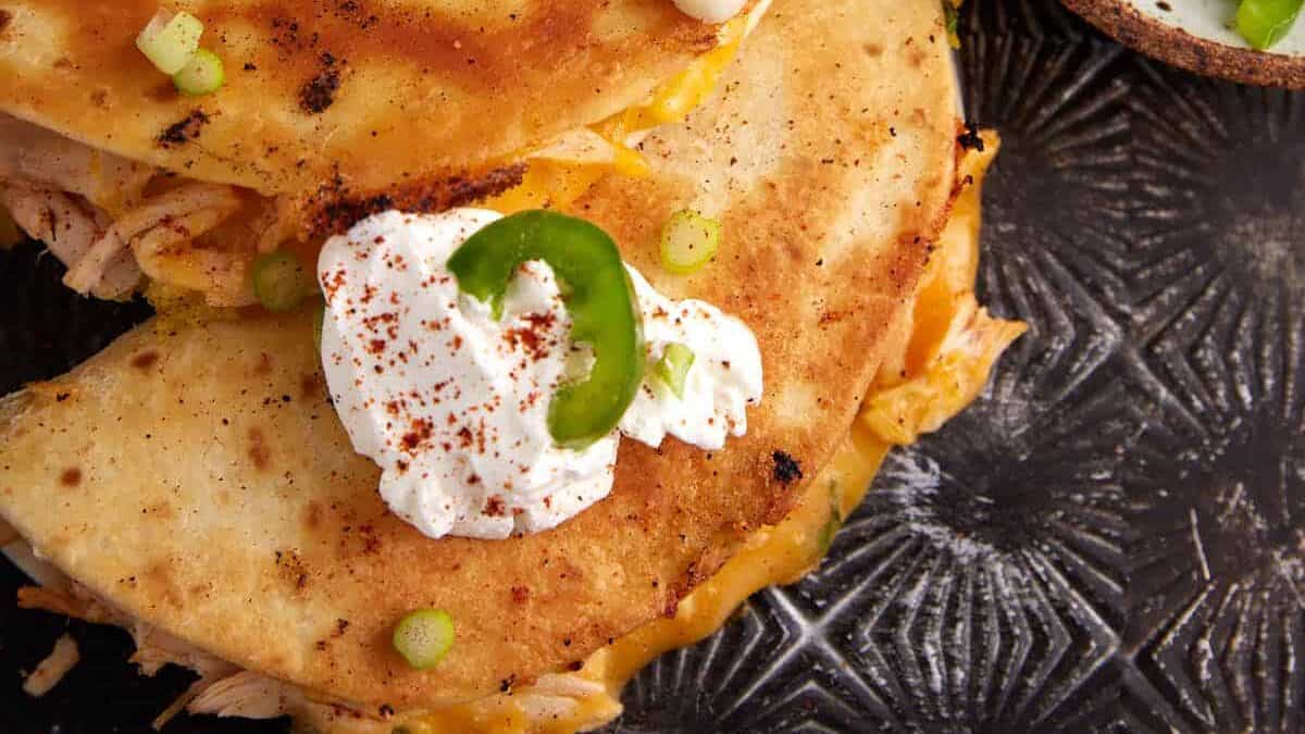 A quesadilla topped with sour cream.