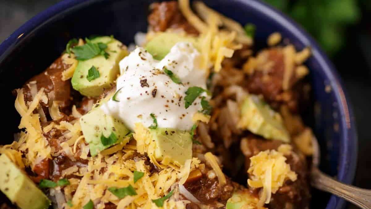 A bowl of chili topped with sour cream.
